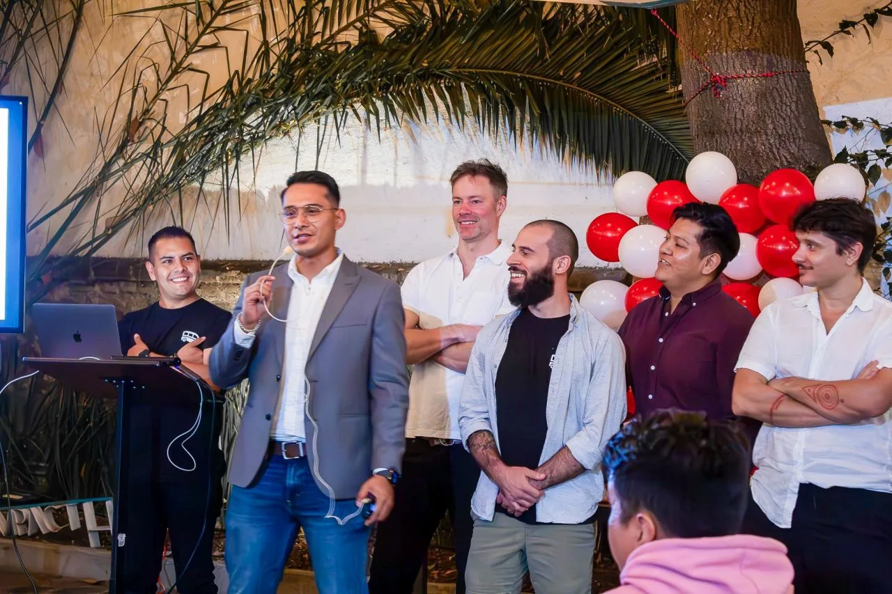 Isaac Lopez habla frente a un grupo, con colegas de pie a su lado