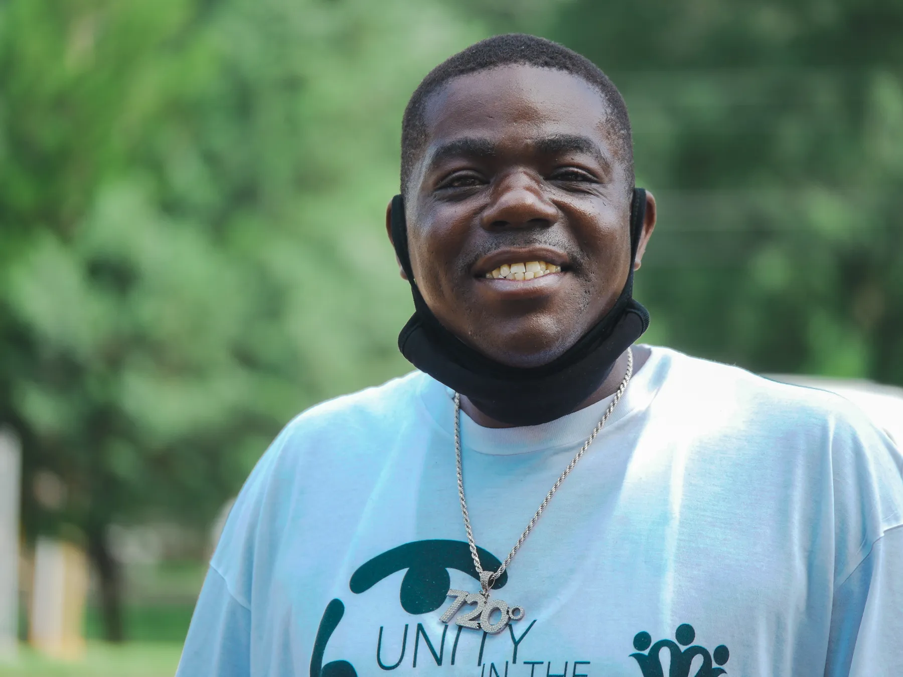 A smiling community member in a Unity in the Community t-shirt